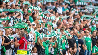 Werder-Fans schwenken ihre Schals im Stadion.