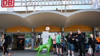 Blick auf den Haupteingang des Haupbahnhofs in Wolfsburg mit ein paar einzelnen Werder-Fans davor.