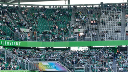 Die Werder-Fans halten ihre Schals in die Höhe.