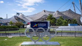 Zu sehen sind Olympische Ringe vor dem Olympiastadion in München.