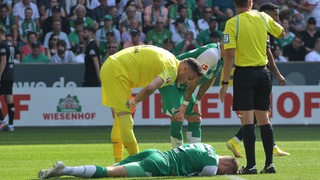 Amos Pieper liegt am Boden. Jiri Pavlenka kümmert sich um ihn.