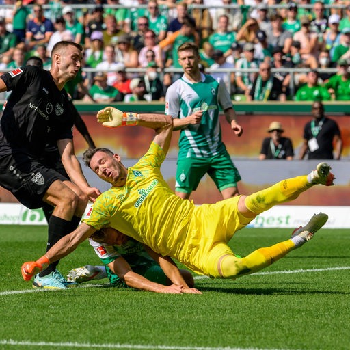 Werder-Torhüter Jiri Pavlenka und Verteidiger Amos Pieper prallen bei einer Abwehrsituation unglücklich zusammen.