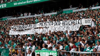 Werder-Fans entrollen in der Ostkurve des Weser-Stadions ein Transparant mit der Aufschrift: "Wolfsburger Polizei, Meister der Heuchelei".