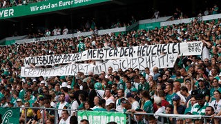 Werder-Fans entrollen in der Ostkurve des Weser-Stadions ein Transparant mit der Aufschrift: "Wolfsburger Polizei, Meister der Heuchelei".