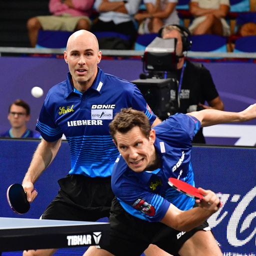 Das österreichische Tischtennis-Doppel Daniel Habesohn und Robert Gardos wehren einen Ball ab.