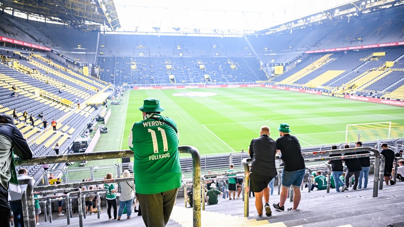 Blick in die noch fast leere Dortmunder Arena, ein Werder-Fan steht bereits im Gästeblock.
