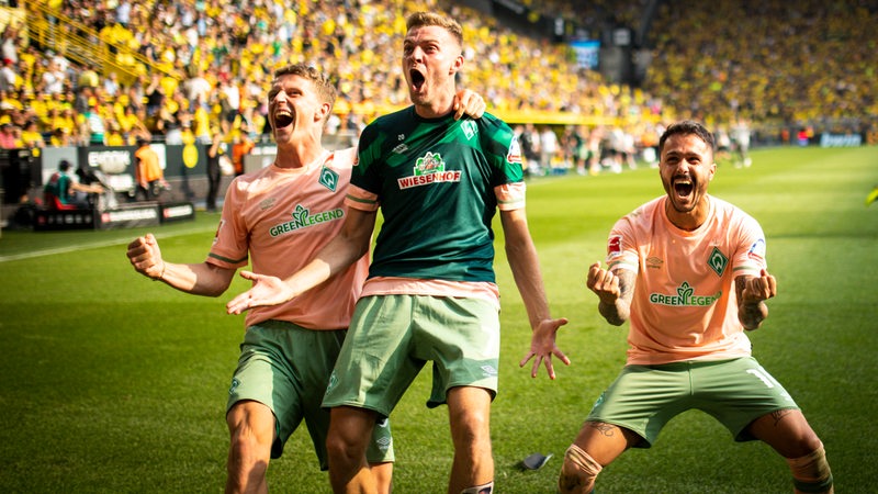 Werder-Spieler Jens Stage, Marvin Ducksch und Leonardo Bittencourt bejubeln ausgelassen den Sieg gegen Dortmund.
