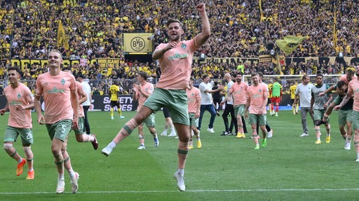 Jubel der Werder-Spieler nach dem Sieg gegen Dortmund, Stürmer Niclas Füllkrug springt in die Höhe und reckt die Faust.