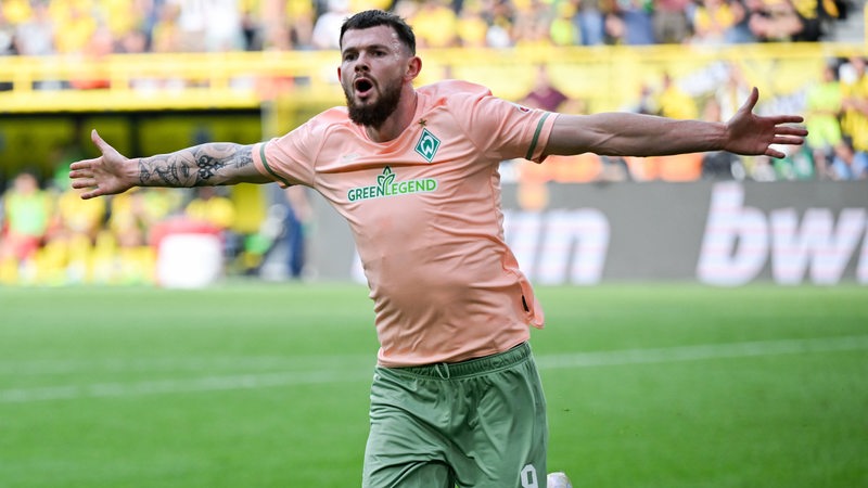 Werder-Matchwinner Oliver Burke feiert mit weit ausgebreiteten Armen seinen Siegtreffer gegen Dortmund.