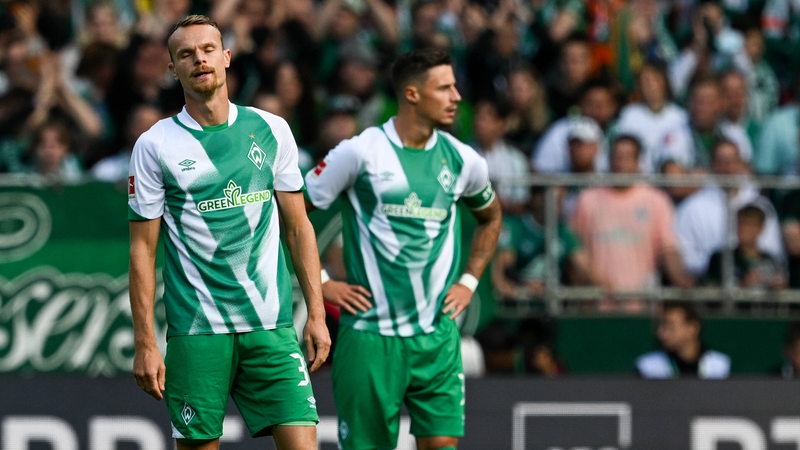 Werder-Spieler Christian Groß und Marco Friedl stehen nach einem Gegentor entgeistert auf dem Rasen.