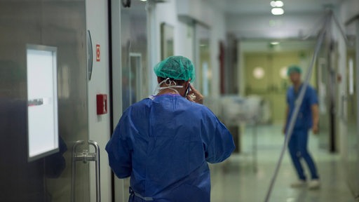 Ein Arzt läuft über einen Gang in einem Krankenhaus.