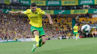 Milot Rashica im gelben Trikot für Norwich City bei einem dynamischen Schuss.