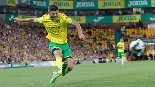 Milot Rashica im gelben Trikot für Norwich City bei einem dynamischen Schuss.