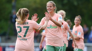 Werder-Spielerinnen Nina Lührßen und Hanna Nemeth klatschen sich nach einem Tor im Pokal ab.
