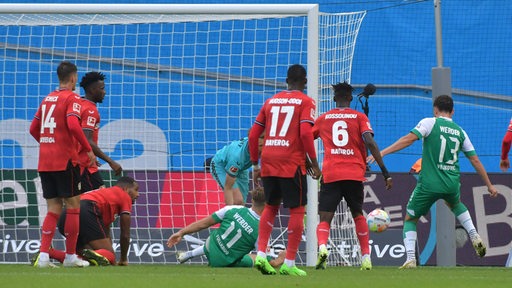 Werder-Spieler Milos Veljkovic kann sich im Getümmel vor dem Leverkusener Tor am rechten Pfosten durchsetzen und den Ball ins Netz schieben.