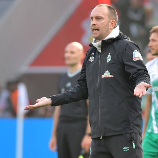 Werder-Trainer Ole Werner gestikuliert ruhig an der Seitenlinie.