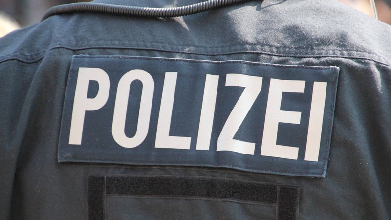 Auf einer Jacken steht das Wort Polizei.