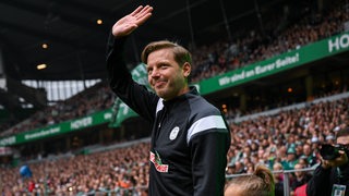 Ex-Werder-Trainer Florian Kohfeldt strahlt winkend, als er beim Abschiedsspiel für Pizarro erstmals seit seiner Entlassung wieder das Weser-Stadion betritt.