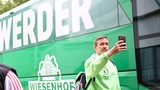 Max Kruse macht bei der Ankunft am Weser-Stadion ein Selfie vor dem Werder-Mannschaftsbus.