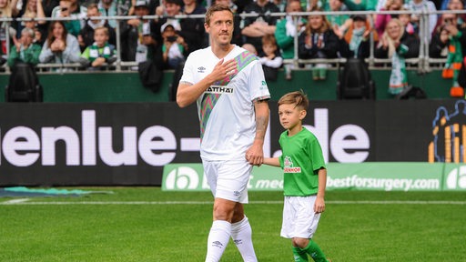 Max Kruse läuft im Weser-Stadion ein und legt dabei die Hand zum Dank für den Applaus aufs Herz.