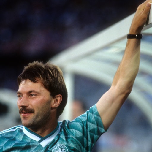 Werder-Spieler Günter Hermann steht während eines Länderspiels 1990 vor der Ersatzbank.