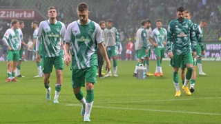 Mehrere Werder-Spieler gehen nach der Mainz-Niederlage mit gesenktem Haupt vom Platz.