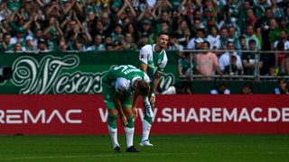 Christian Groß und Marvo Friedl stehen gemeinsam auf dam Platz im Weser-Stadion.