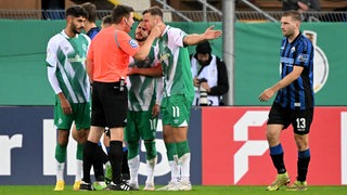 Werder-Stürmer Niclas Füllkrug diskutiert aufgeregt mit dem Schiedsrichter, der sein Tor aberkannt hat.