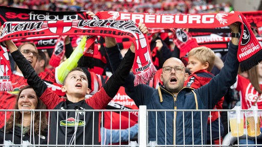 Freiburger Fans jubeln auf der Tribüne.