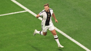 Werder-Stürmer Niclas Füllkrug im WM-Spiel gegen Spanien am Ball, verfolgt von zwei Gegenspielern.