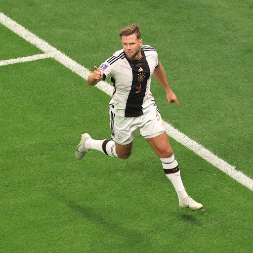 Werder-Stürmer Niclas Füllkrug im WM-Spiel gegen Spanien am Ball, verfolgt von zwei Gegenspielern.