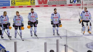 Spieler der Fischtown Pinguins stehen enttäuscht nebeneinander auf dem Eis nach dem Spiel.