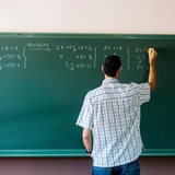 Lehrer schreibt an Tafel