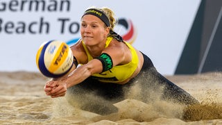 Die Bremer Beachvolleyballerin Kim van de Velde springt einem Ball entgegen.