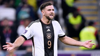 DFB-Stürmer Niclas Füllkrug blickt verwundert zum Schiedsrichter.