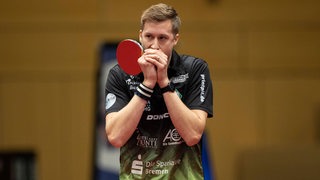 Werders Tischtennis-Profi Mattias Falck pustet sich in die Hände.