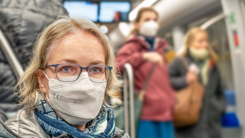 Eine Frau trägt freiwillig Maske in der U-Bahn.