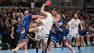 Der Handball-Nationalspieler Philipp Weber wird im Testspiel gegen Island von zwei Gegenspielern intensiv bearbeitet beim Wurfversuch.