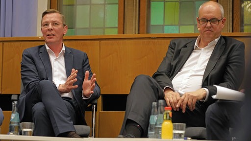 CDU-Spitzenkandidat Frank Imhoff (links) und Bürgermeister Andreas Bovenschulte (SPD) sitzen auf einem Podium.