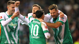 Mehrere Werder-Spieler bejubeln einen Treffer.