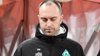 Werder-Trainer Ole Werner schaut nach der Niederlage gegen Köln enttäuscht nach unten.