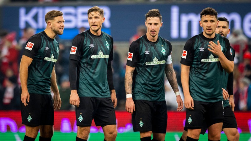 Mehrere Werder-Spieler trotten über den Platz.