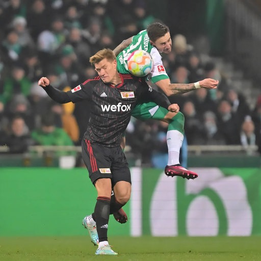 Union-Angreifer Kevin Behrens im Zweikampf mit Werder-Kapitän Marco Friedl.