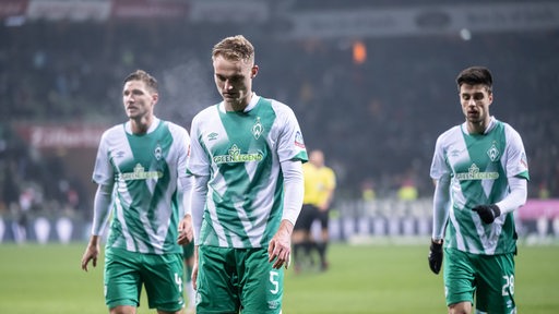 Die Werder-Spieler verlassen mit hängenden Köpfen den Platz.