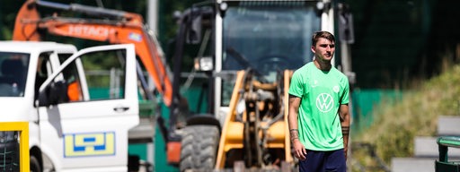 Maximilian Philipp geht im Wolfsburg-Dress in Richtung Trainingsplatz. Hinter ihm sind Baustellenfahrzeuge zu sehen.