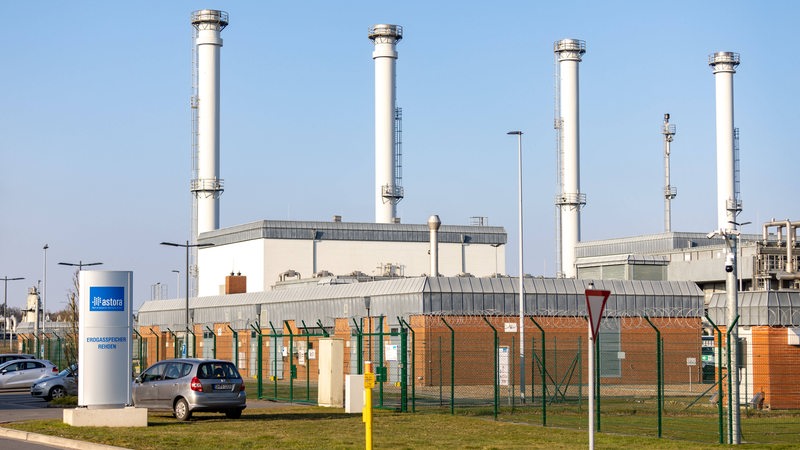 Die Schornsteine eines Gasspeichers ragen in den Himmel.