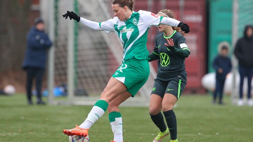 Werder-Stürmerin Stefanie Sanders im Zweikampf mit einer Wolfsburger Spielerin im Testspiel.