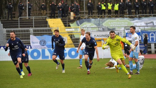 Spieler des VfB Oldenburg stürmen nach einem späten Tor jubelnd über den Rasen.