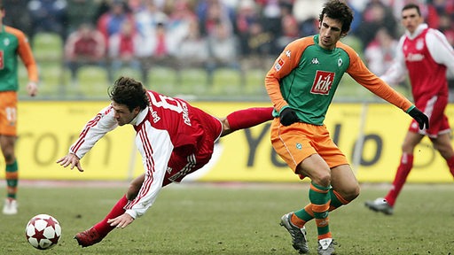 Werder-Spielmacher Johan Micoud blickt seinem zu Boden gehenden Gegenspieler nach.