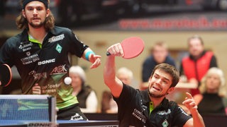 Werders Tischtennis-Profis Cristian Pletea und Kirill Gerassimenko kämpfen nebeneinander im Doppel.